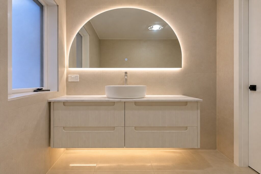 Bathroom vanity with a backlit arched mirror and LED strip under the vanity