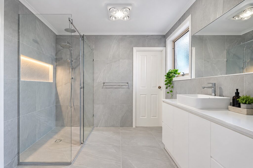 Renovated bathroom with a walk-in shower, LED niche lighting and a ceiling heat lamp