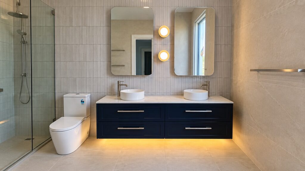 Double vanity with two wall lights between the mirrors and LED strip lighting under the vanity