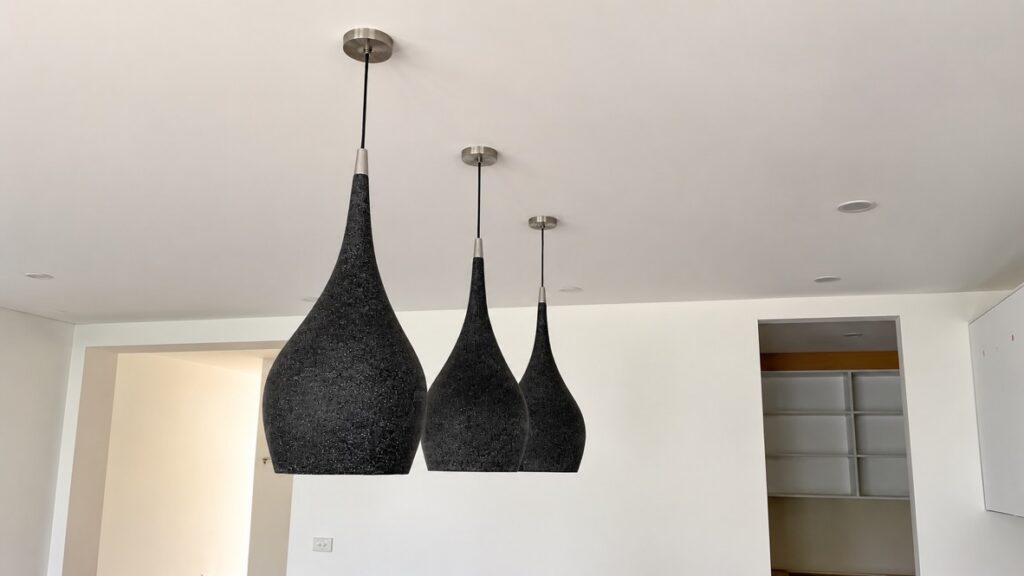 Three black pendant lights hanging in a renovated kitchen