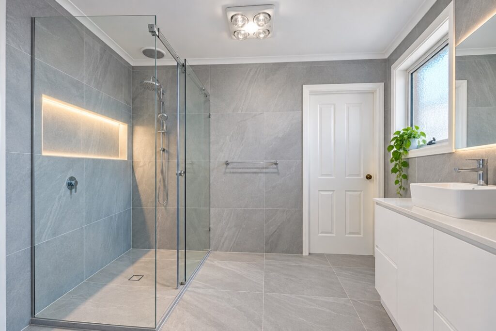Renovated bathroom with a ceiling heat, fan and light unit and LED strip lighting in the shower niche