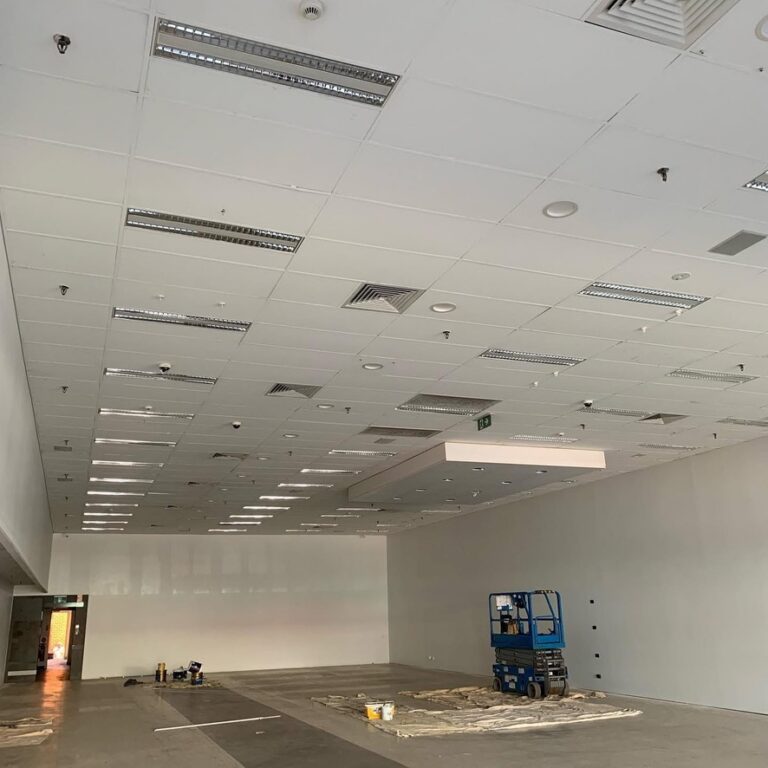 Empty commercial tenancy with ceiling lighting and air conditioning vents