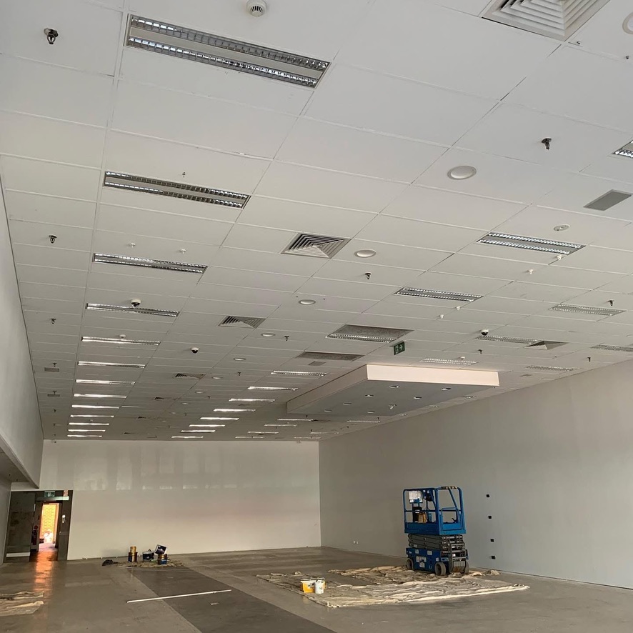 Empty commercial tenancy with ceiling lighting and air conditioning vents