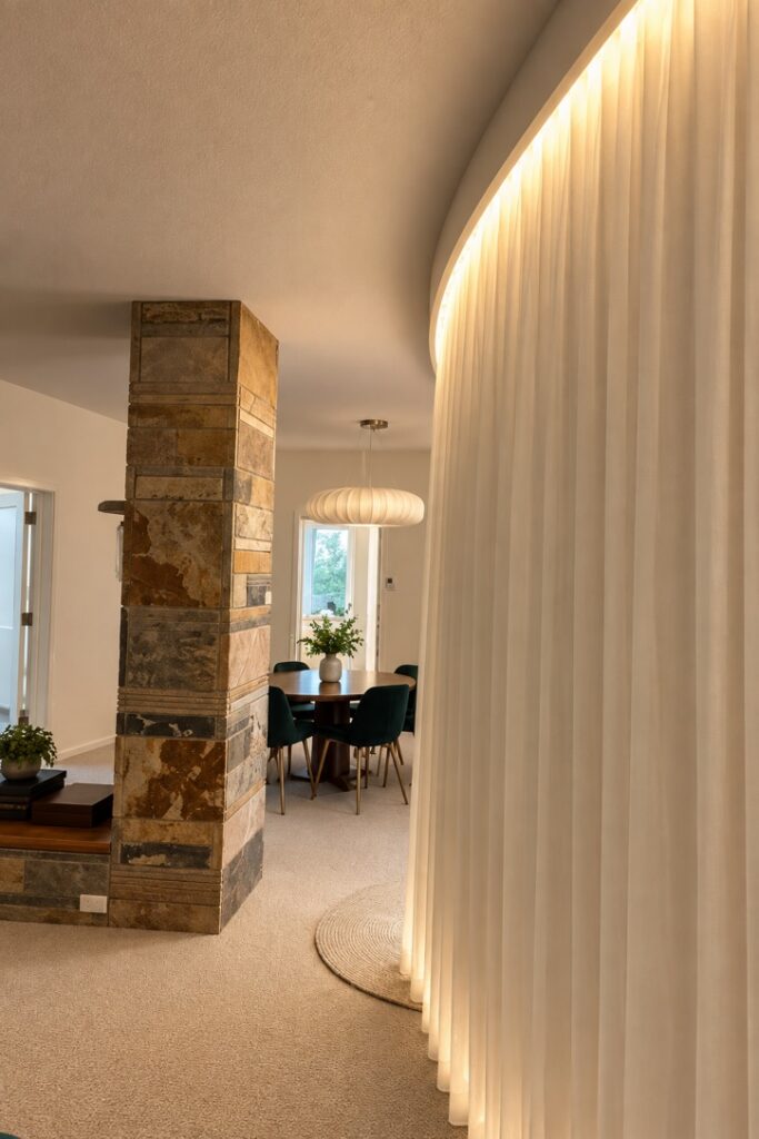 Concealed LED strip lighting along a curved ceiling and curtain line
