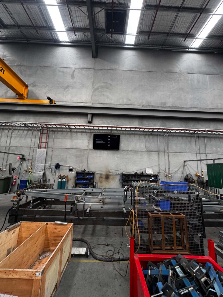 Factory interior with LED high-bay lighting and a wall-mounted screen