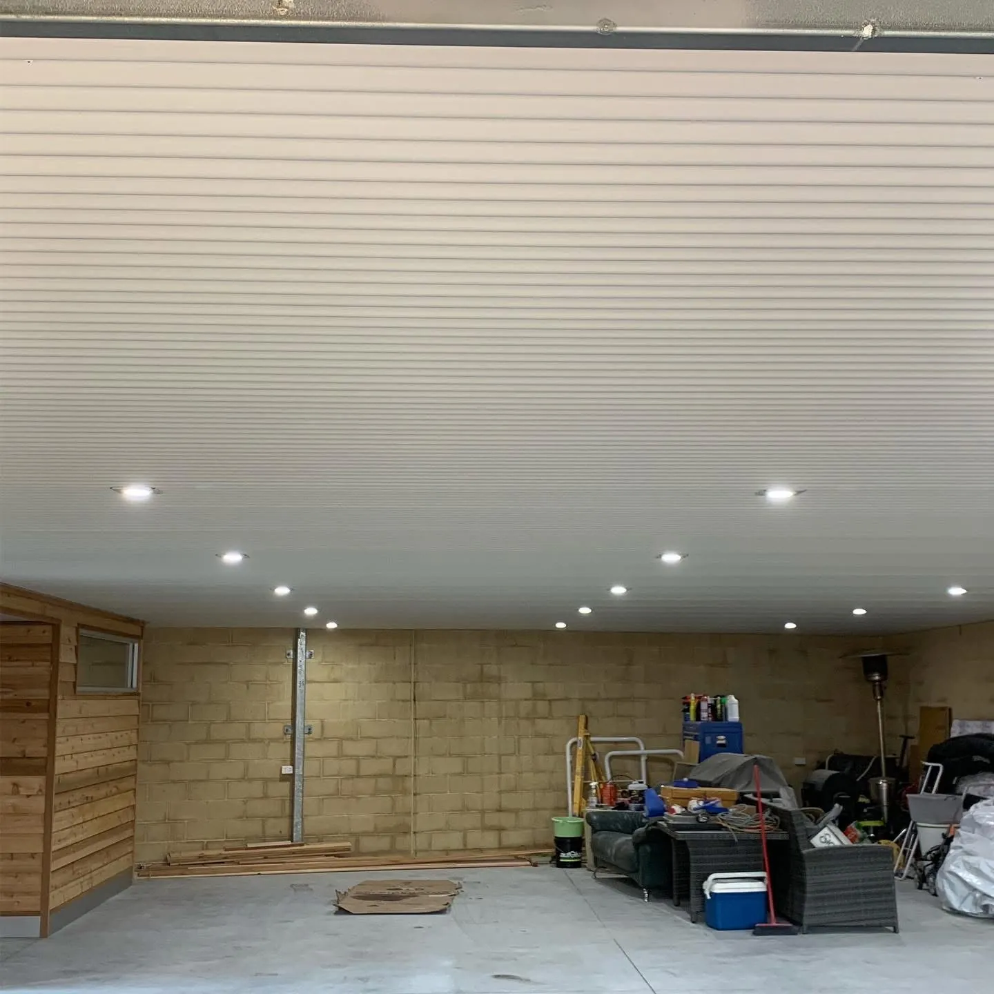 Garage ceiling lit by LED downlights set into lined panels