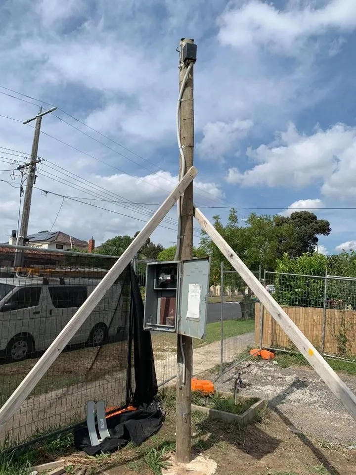 Temporary builder’s supply pole with a meter enclosure on a building site
