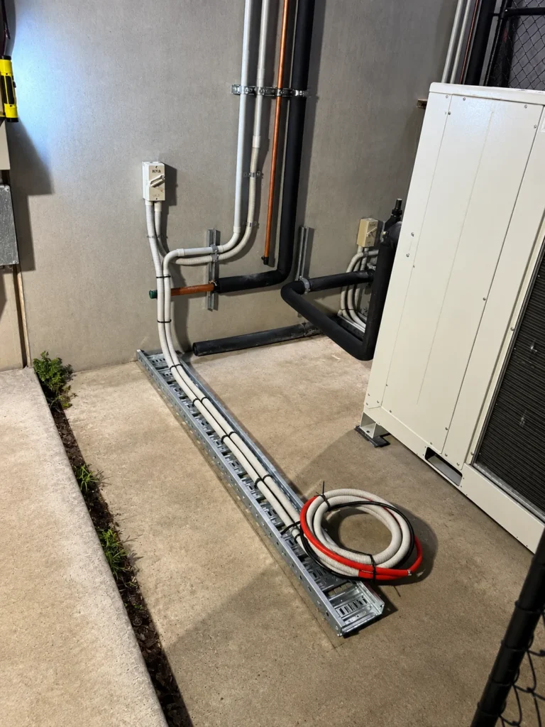 Conduit and insulated services run in a duct to an outdoor commercial unit