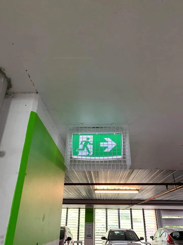 Illuminated emergency exit sign installed on a ceiling