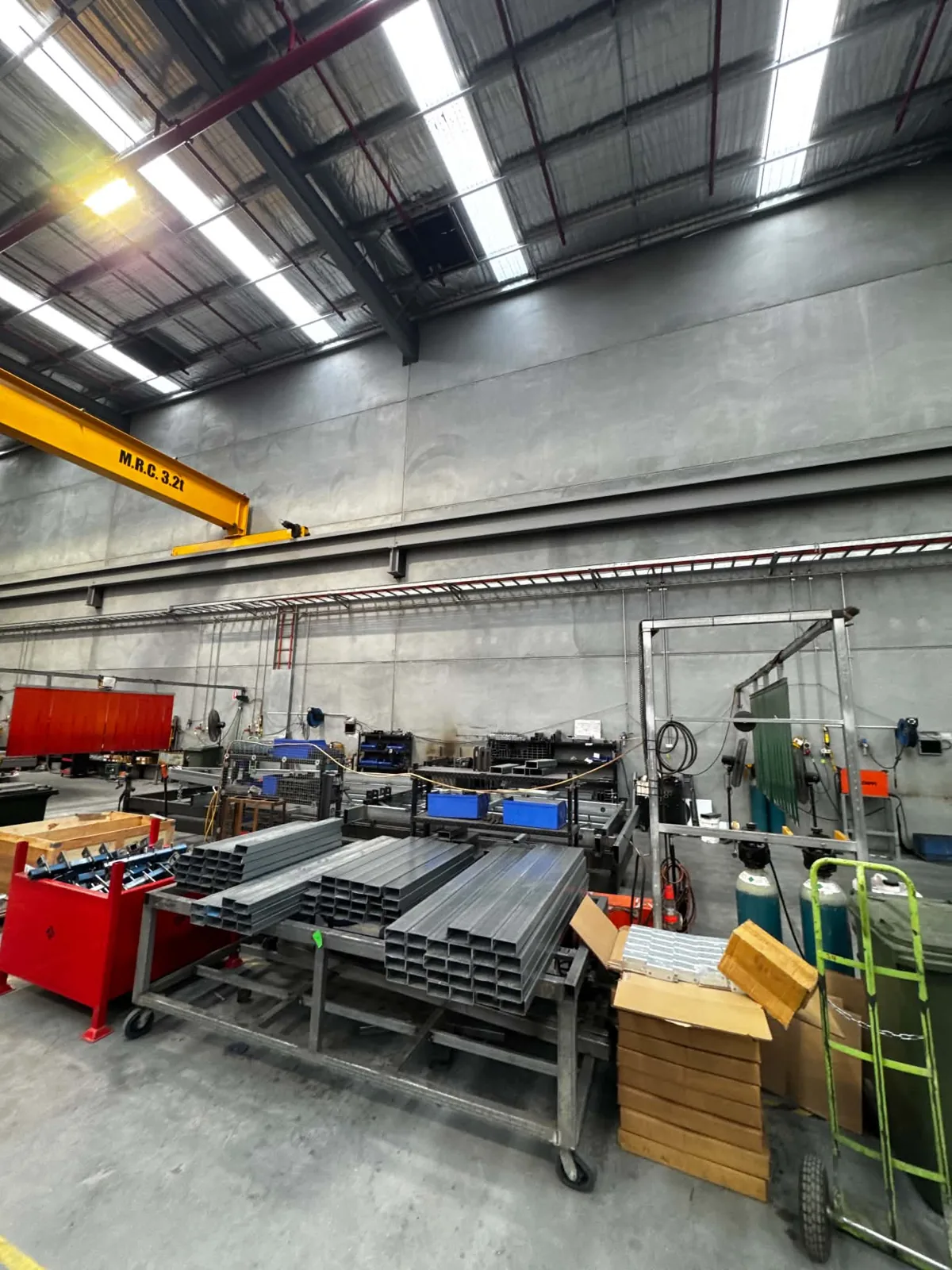 Factory floor with rows of LED high-bay lights under a steel roof