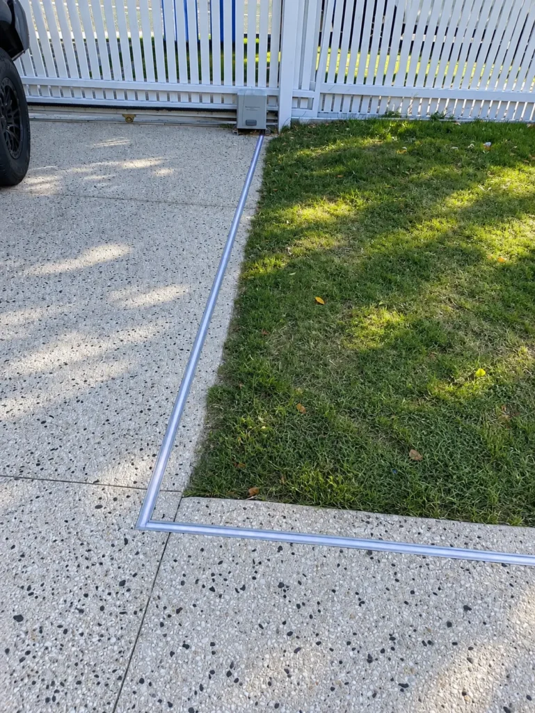 Close view of the recessed LED strip turning a corner between the driveway and lawn
